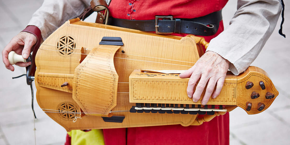 Person playing a hurdy gurdy (a medieval instrument)