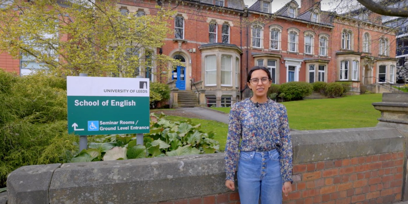 A screenshot from the School of English tour video. Student, Alex, stands outside the School entrance.