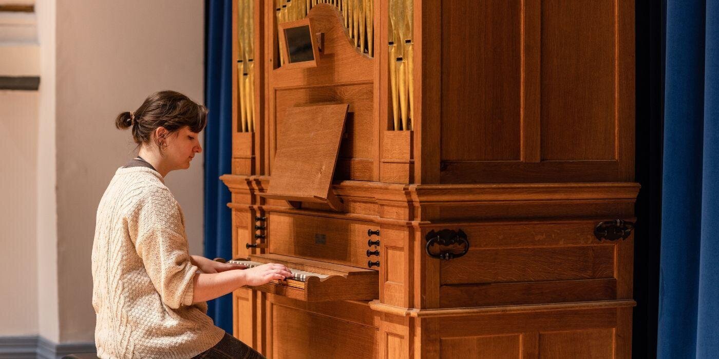 Female student playing the School of Music's organ in the Clothworkers Centenary Concert Hall.
