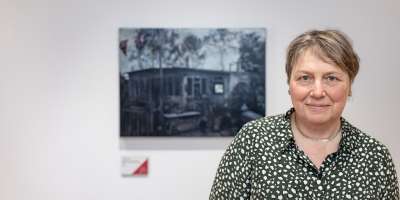 Dr Judith Tucker standing in front of her painting at Leeds Artist Show 2023