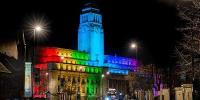 An image of the Parkinson Building illuminated in the colours of the LGBTQ+ flag.