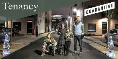 A picture from the Tenancy project in Manchester - a family standing in a dark street with a dog on a lead
