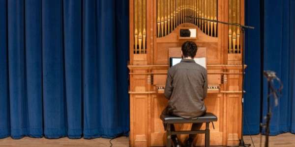 Male student practicing on the School of Music's organ in the Clothworkers Centenary Concert Hall.