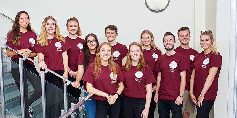 A group of students from the history society wearing matching society t-shirts.
